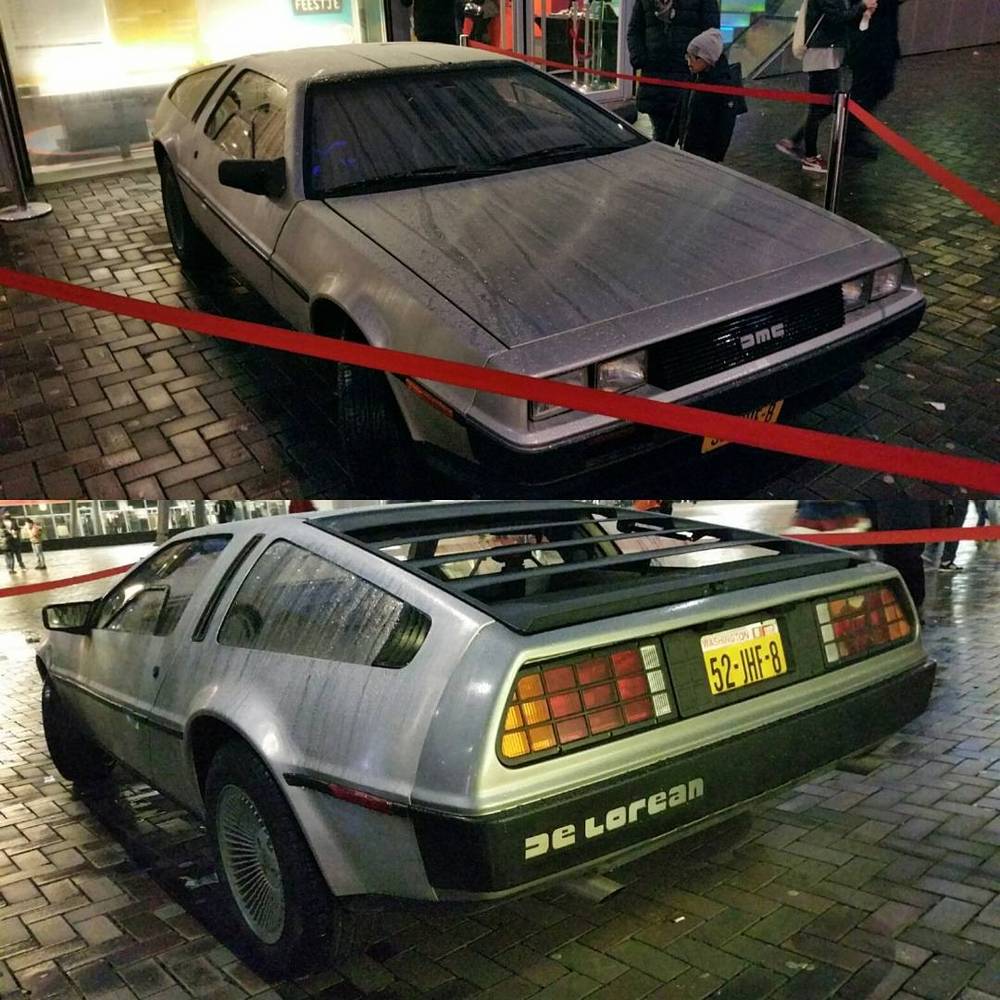 A silver DeLorean car on display indoors, roped off, shown from front and rear angles.