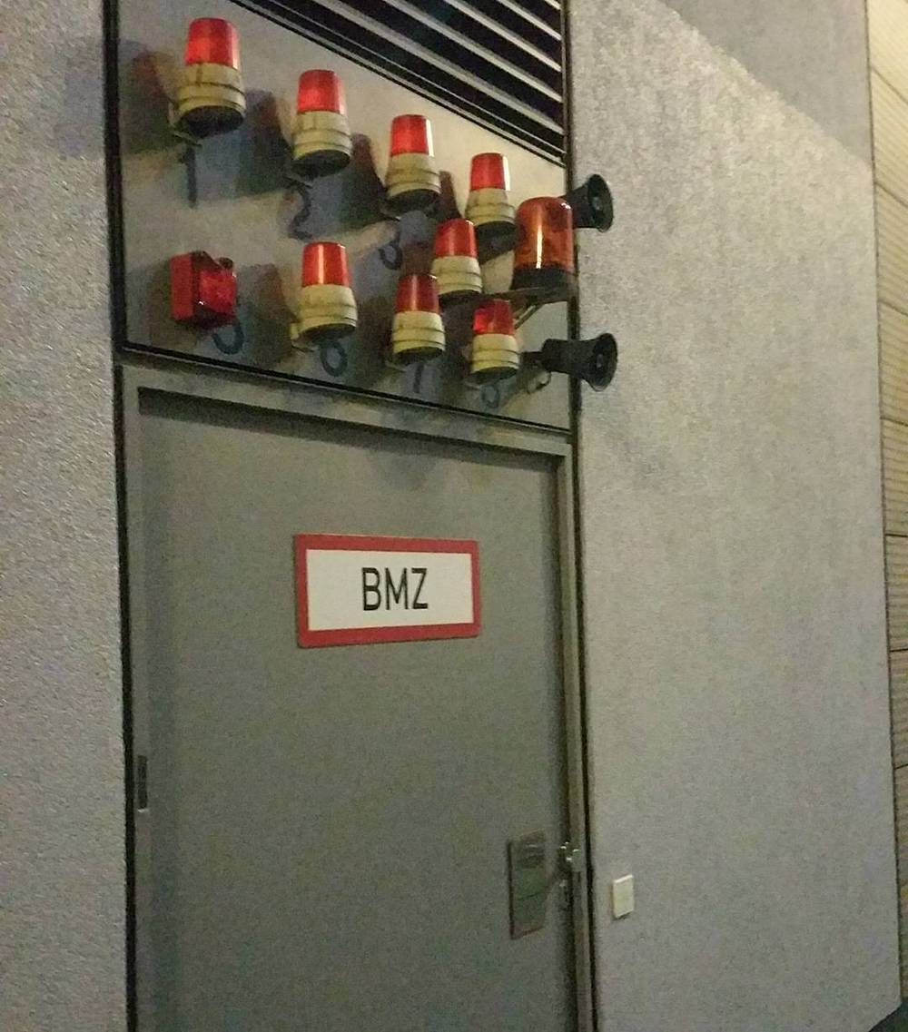 A row of decorative lanterns mounted beside a door labeled "BMZ".