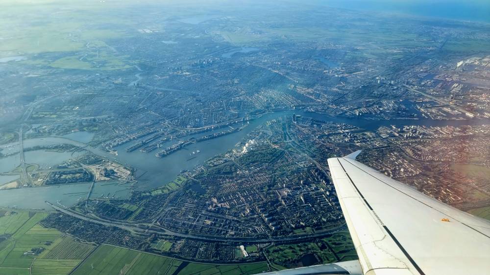 Aerial view from an airplane window of a city and coastline.