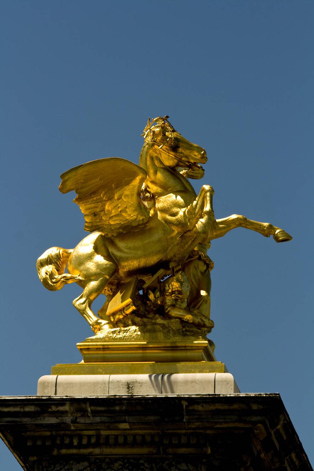 A gilded statue of Pegasus with a rider crowns a pillar on Pont Alexandre III.