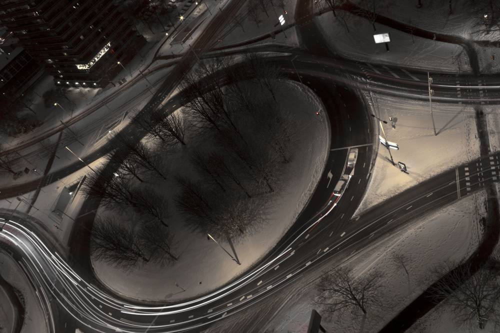 The same snowy roundabout is shown again in a moodier, near-monochrome tone.