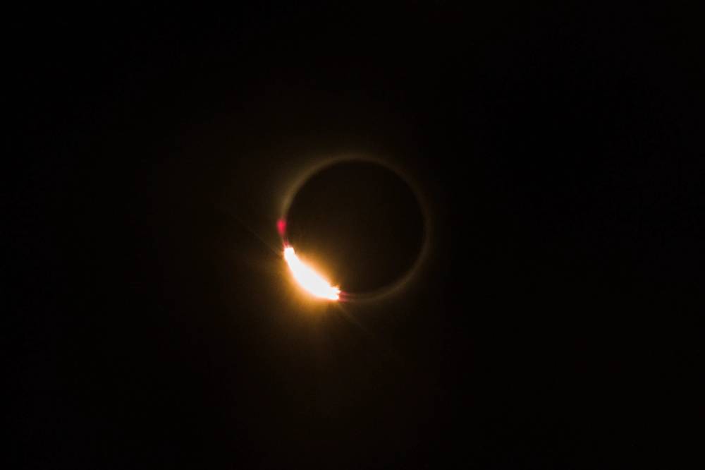 The Moon has almost blocked the Sun: only a ring of light and a little flash in the lower part of the Sun is visible.