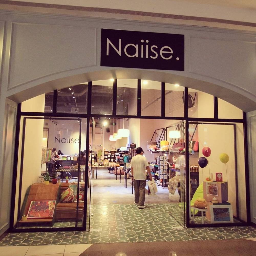 Storefront of a shop called "Naiise" displaying various design goods.