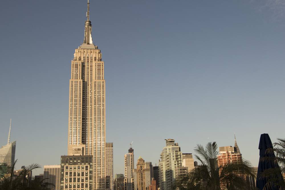 The Empire State Building stands against a clear evening sky.