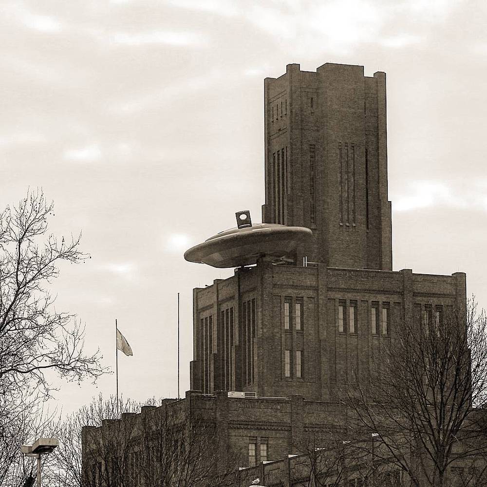 An industrial brick water tower building under a cloudy sky.