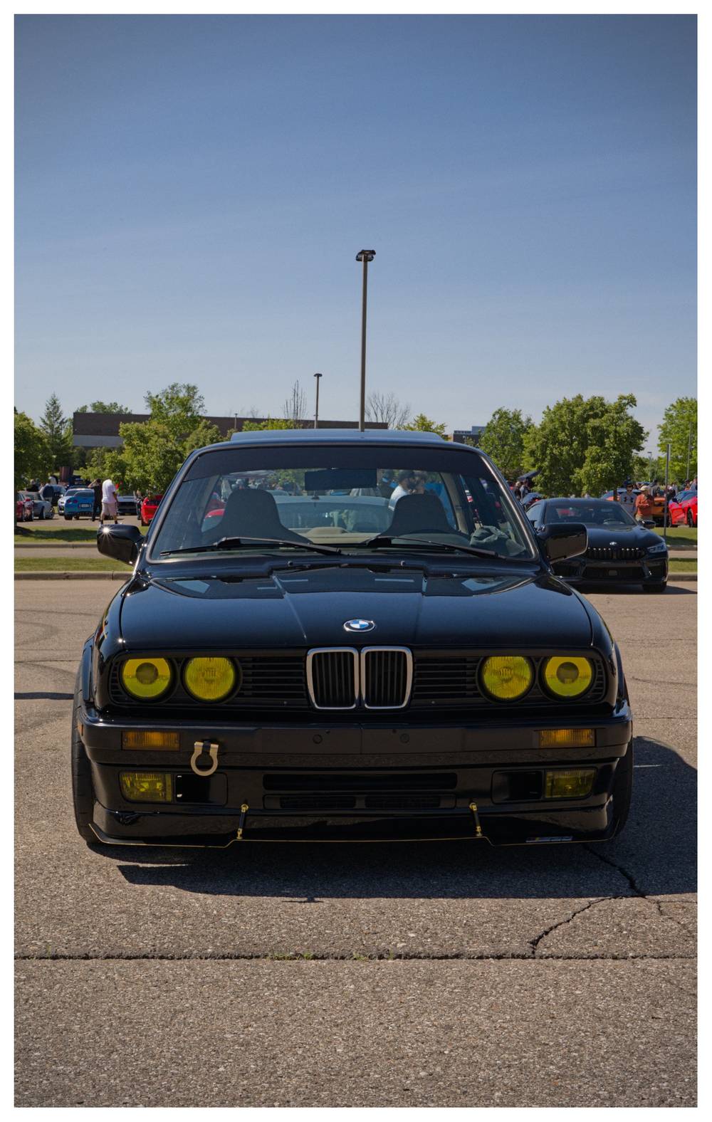 Front view of a square body black BMW with yellow/gold accents