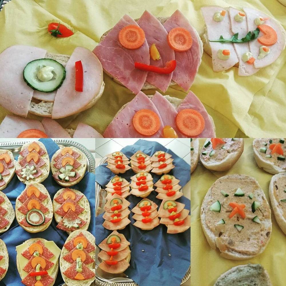 A collage of open sandwiches decorated with vegetables to look like faces, arranged on trays.
