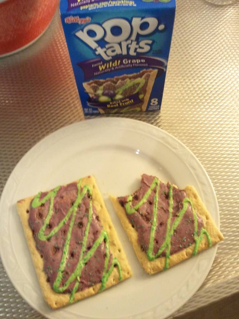 Two toaster pastries with green icing sit on a plate.