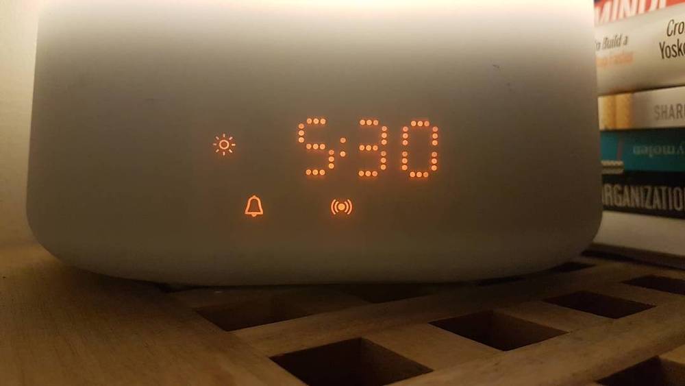 An alarm clock display showing 5:30 with sun and bell icons illuminated.