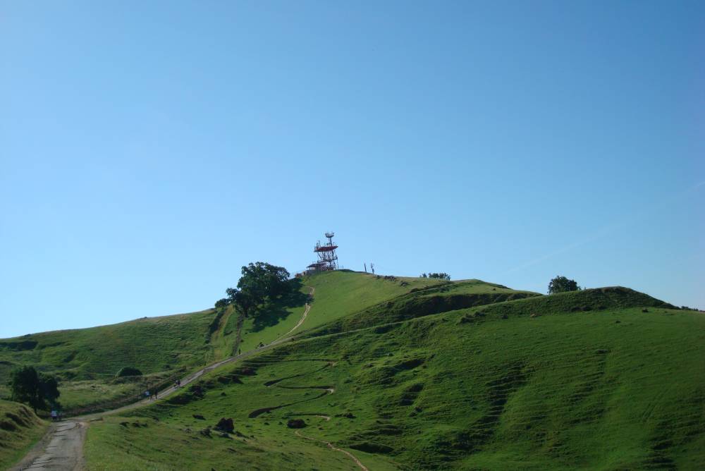 Scenic view of electrical tower atop a hill