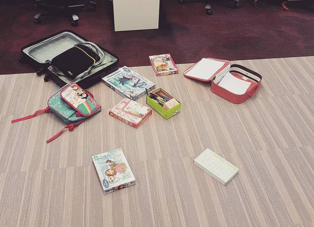 A suitcase and several packed cases and boxes laid out on the floor, ready for a trip.