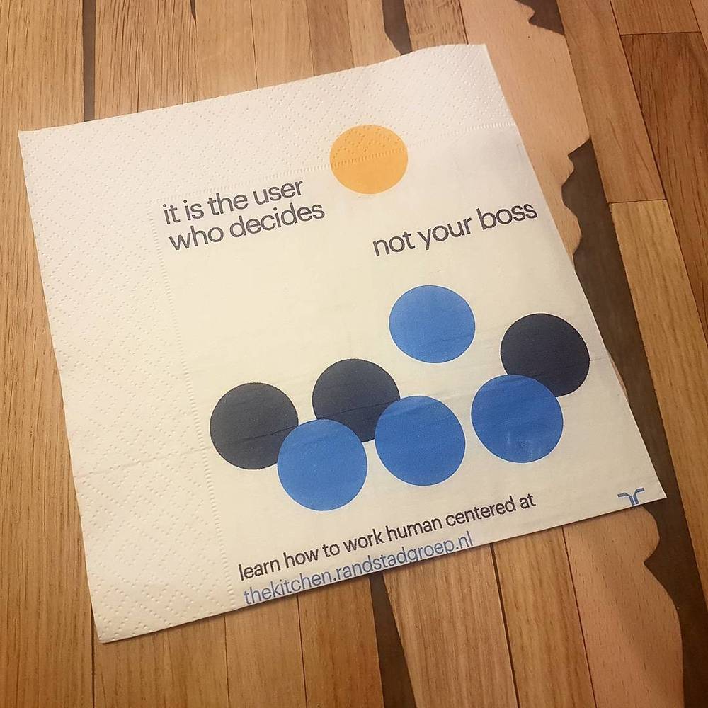 A paper napkin printed with the quote 'it is the user who decides, not your boss'.