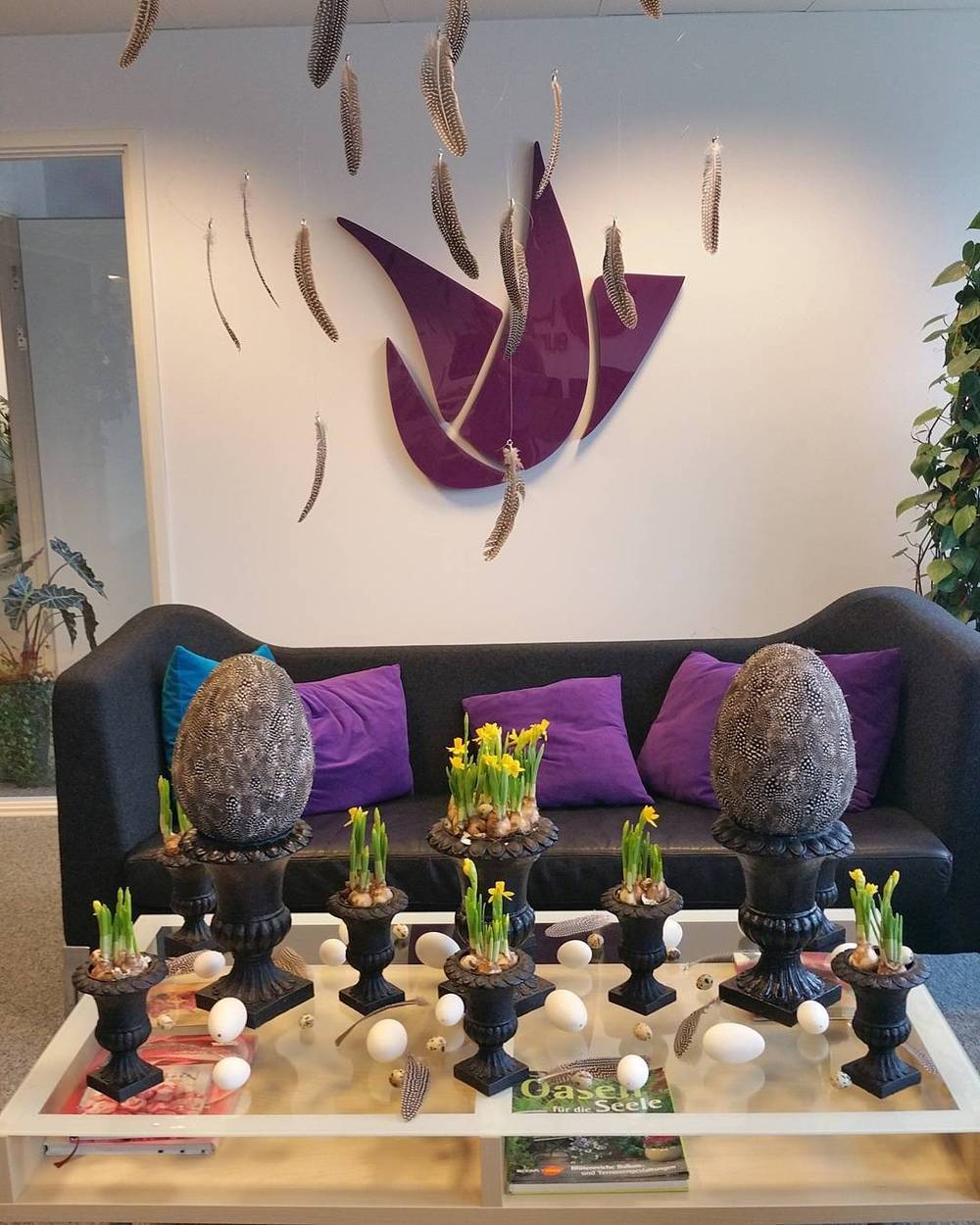 A hotel lobby seating area decorated with purple cushions and Easter egg ornaments.