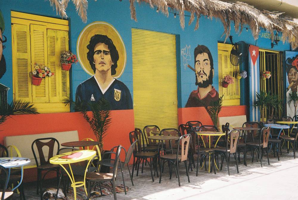 A picture of a cafe with various murals of famous people.