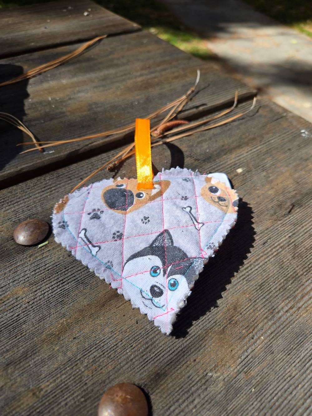 The back of the quilted heart with a cartoon dog pattern with a husky, pug, paws prints and bones.