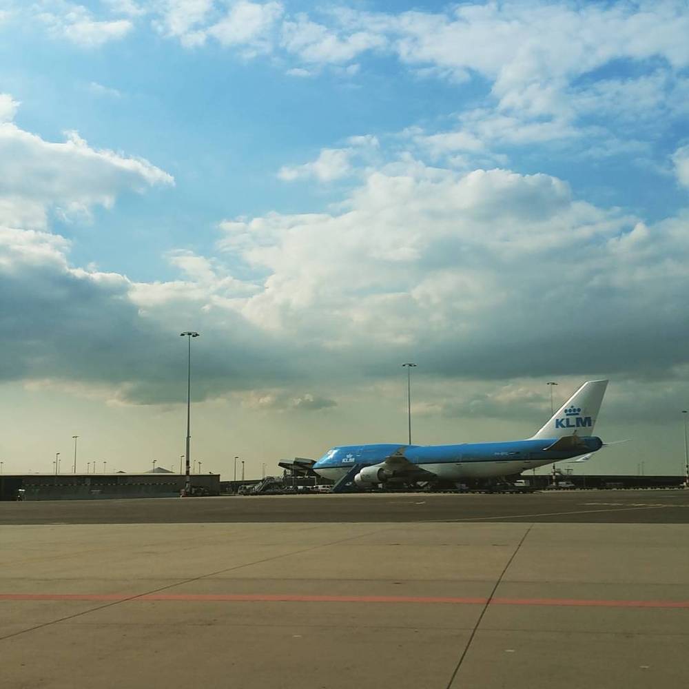 A KLM Boeing 747 parked on the tarmac under a partly cloudy sky.