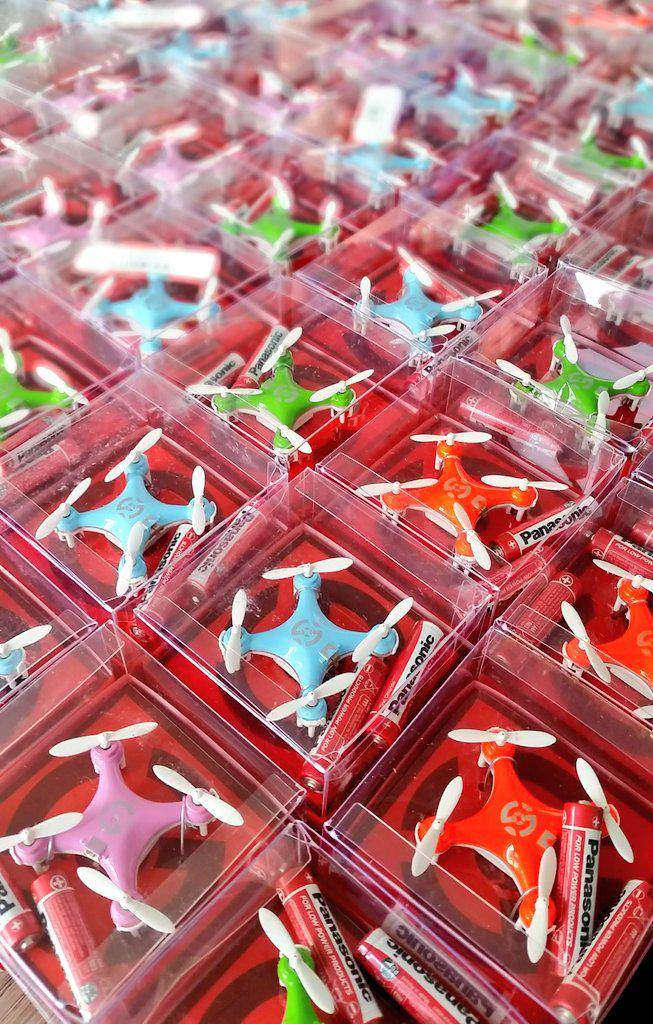 Rows of small toy drones packaged in red boxes on a store display.
