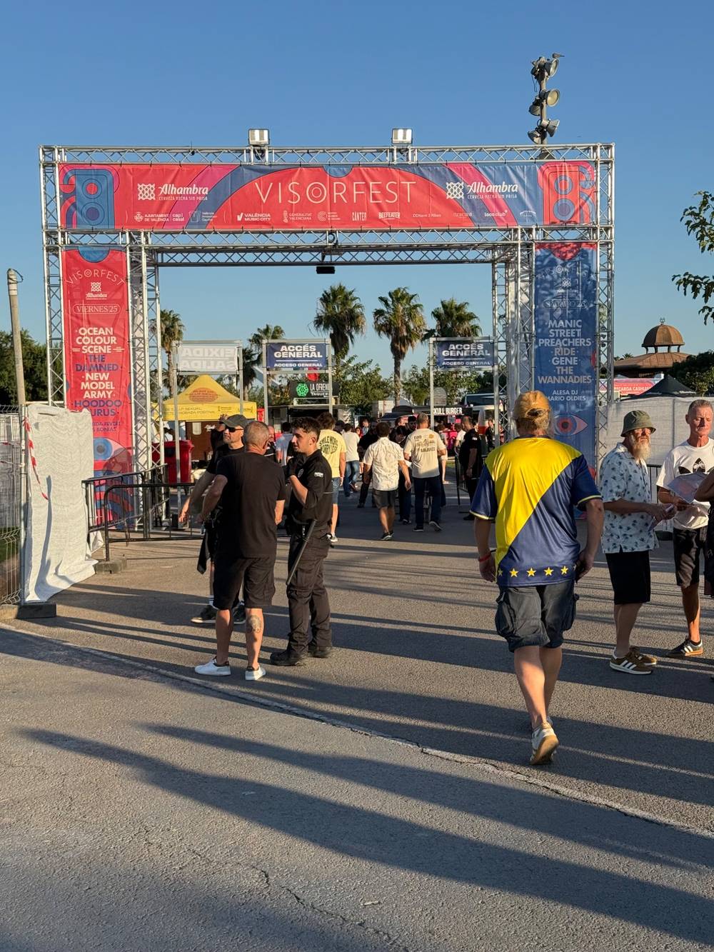 Middle-aged indie fans walking through an arch with the words "Visorfest" above them.