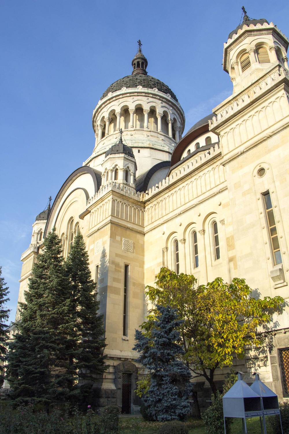 The Orthodox Cathedral's domed towers against a clear blue sky, framed by pine trees.