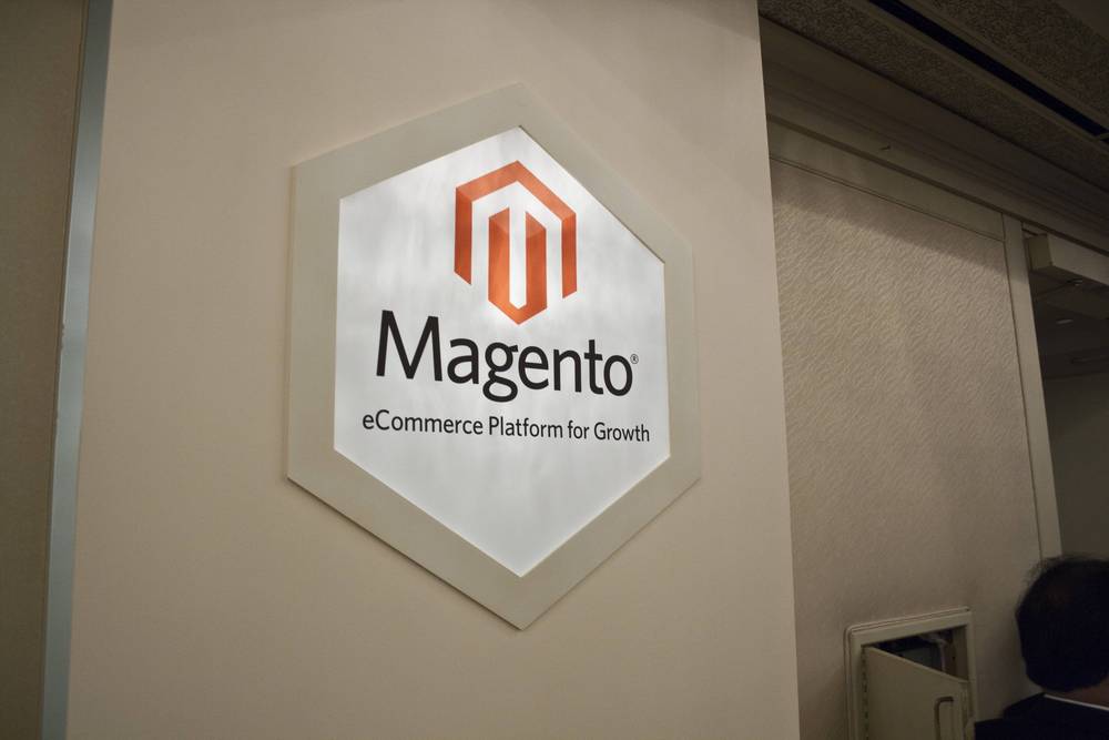 A silver Magento eCommerce Platform for Growth sign is mounted on a wall.