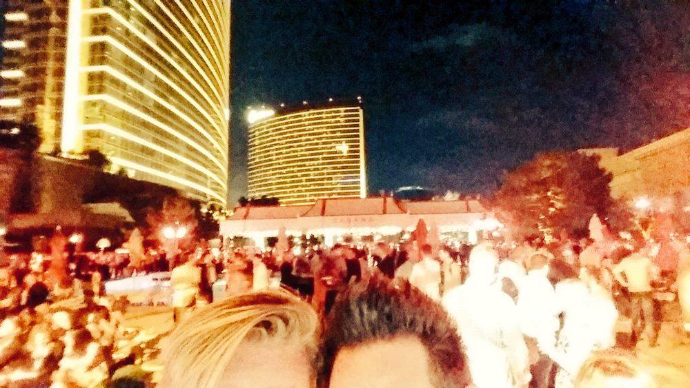 A blurred, warmly lit photo of a crowd at an evening hotel event.