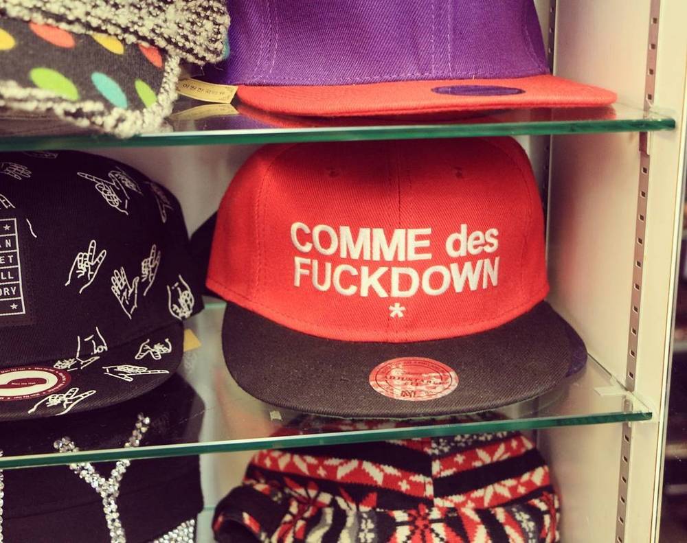 A display of colourful branded caps including one reading "Comme des Fuckdown".