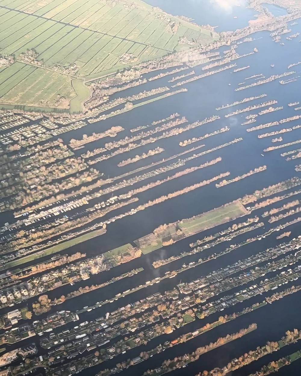 An aerial view of a Dutch lake town with waterside houses, boats, and canals.