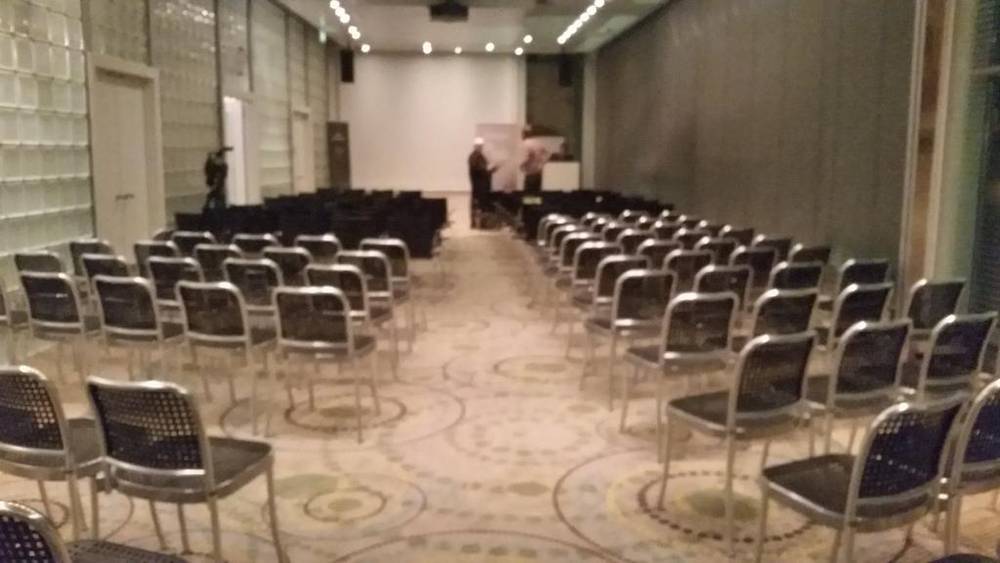 Rows of empty chairs set up in a meeting room ahead of a workshop.