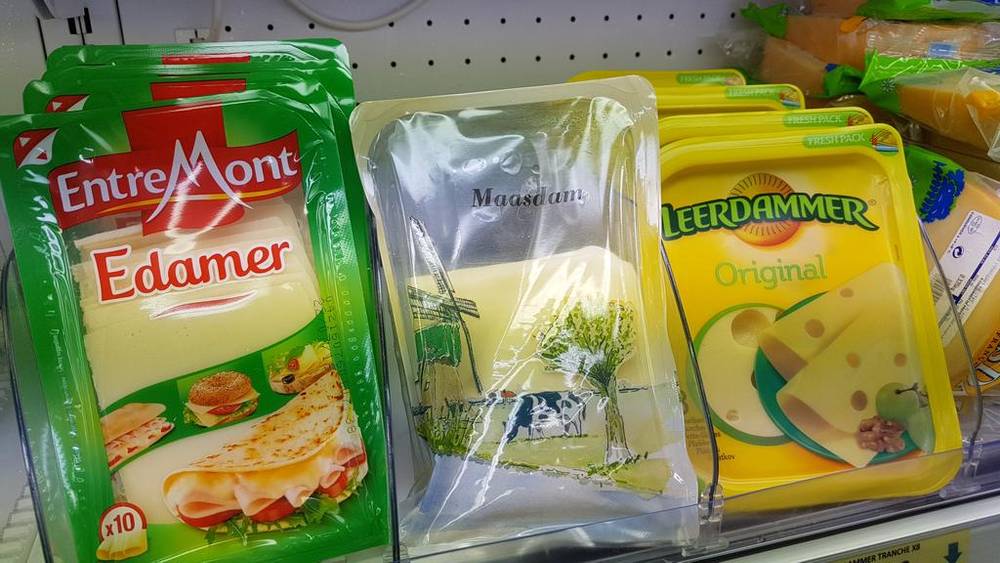 Packages of Dutch cheese, including Edamer and Leerdammer, on a store shelf abroad.