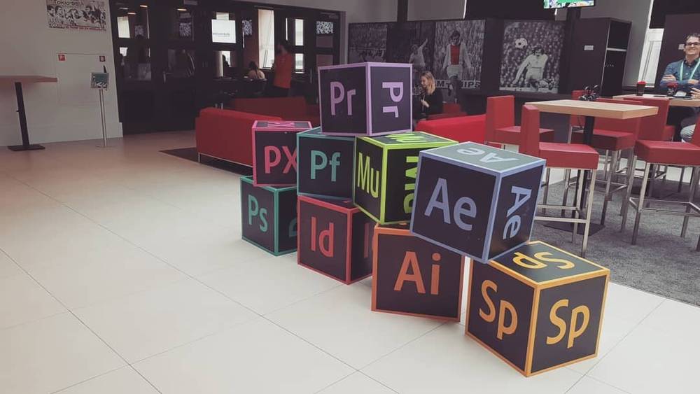Giant cube decorations printed with Adobe Creative Cloud app icons in a lobby.