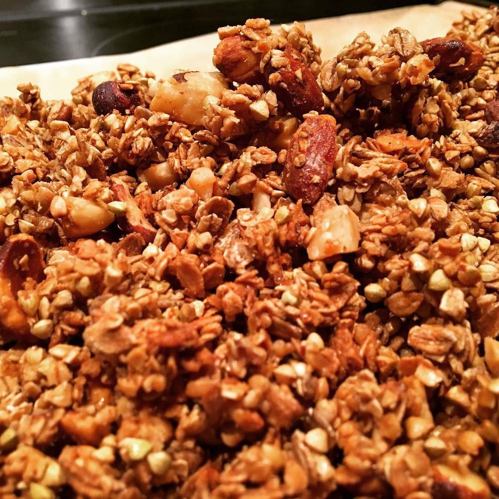 A close-up of baked granola with nuts, ready to eat.