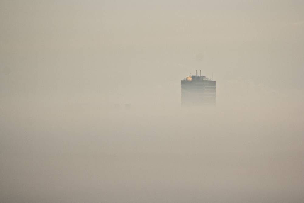 The Fortis office tower barely visible through thick morning mist.