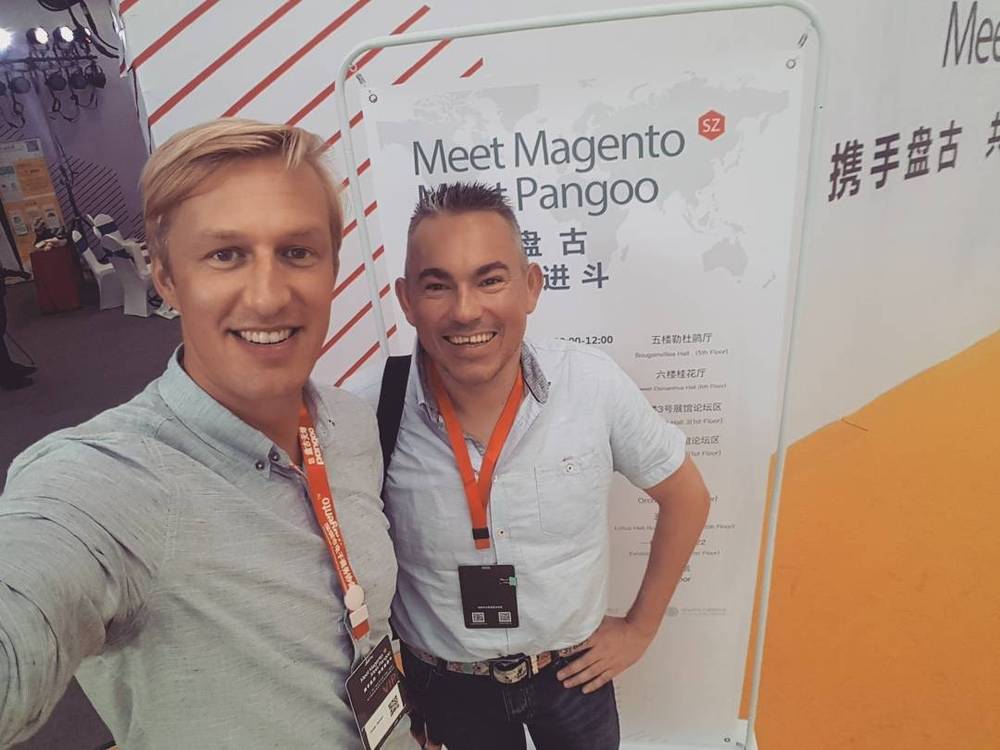 Selfie with a colleague in front of the "Meet Magento Meet Pangoo" event signage.
