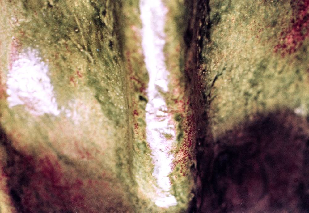 An extreme close up of a green and brown ceramic surface.