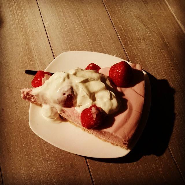 A slice of pie topped with whipped cream and fresh strawberries on a plate.