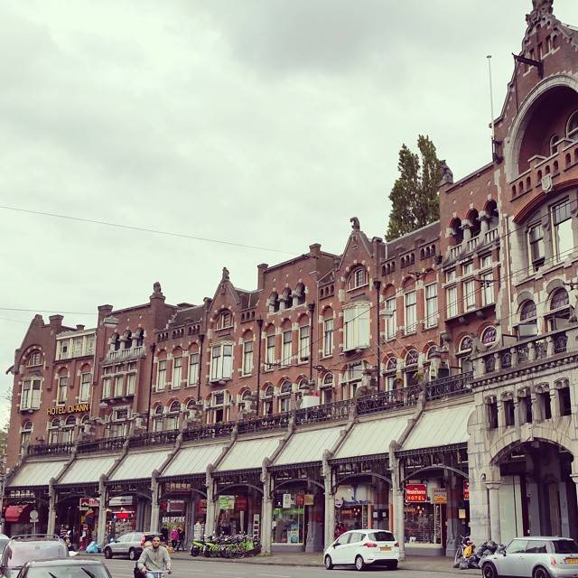 A row of ornate historic buildings with shops along a street.