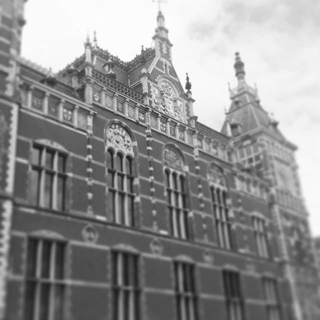 A black-and-white photo of an ornate historic railway station facade.