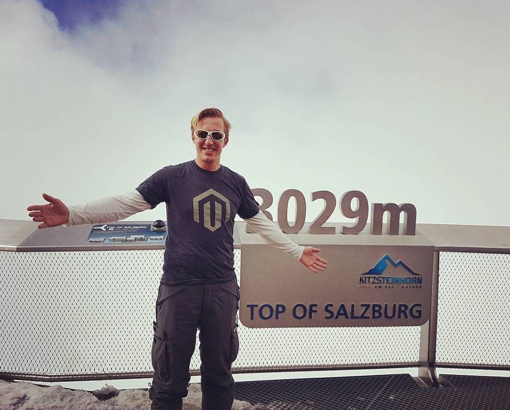 A man poses at the "Top of Salzburg" summit sign, 3029 metres up on the Kitzsteinhorn.