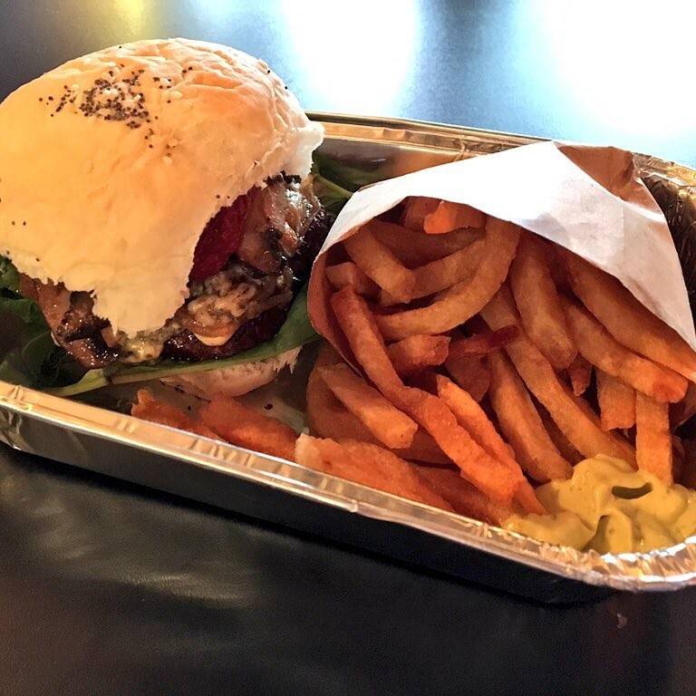 A takeaway tray with a burger and french fries.