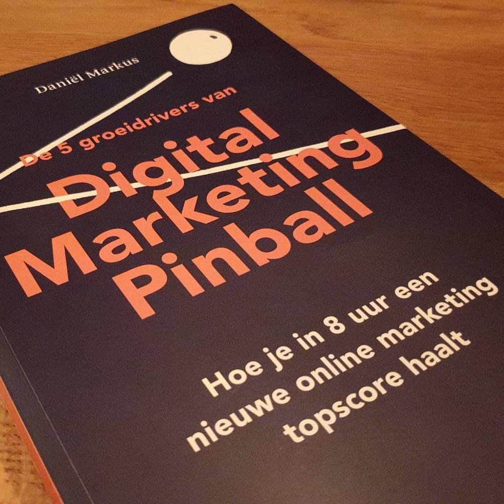 The book "Digital Marketing Pinball" by Daniel Markus rests on a table.