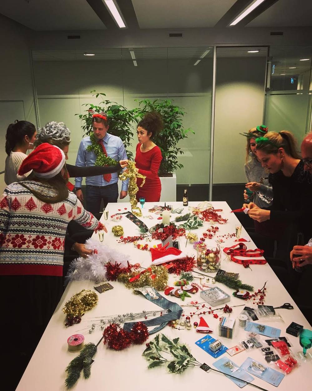 A table covered with Christmas decorations, including tinsel, ornaments, and a Star Wars figure.