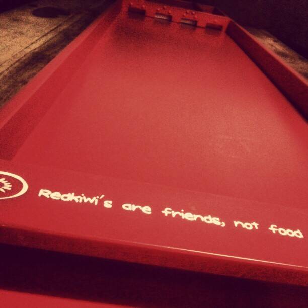 A red plastic serving tray engraved with the words 'Redkiwi's are friends, not food'.