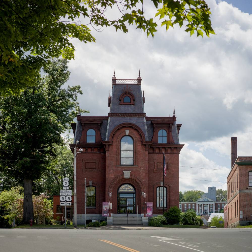 View of front of the Athenæum from the road. It's a red brick Victorian building with a slate roof.