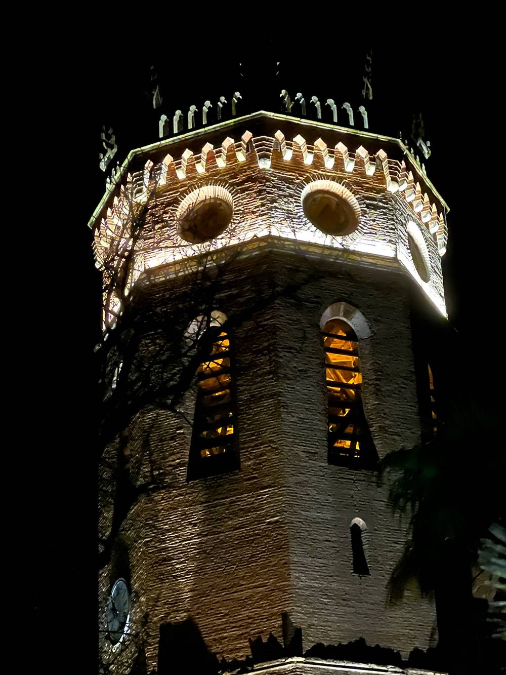 An old looking Tower by Night, artificialy illuminated, zoomed on top