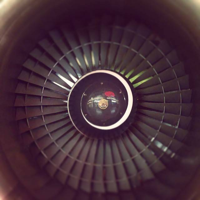 Close-up of a jet engine's turbine blades, softly lit.