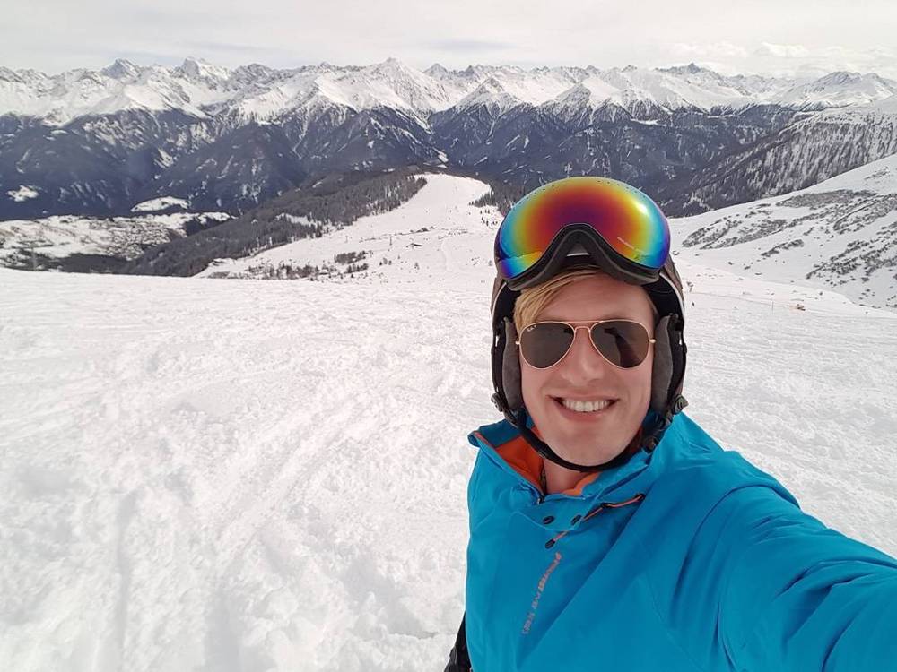 A panoramic view of snow-covered mountains and a ski resort valley.