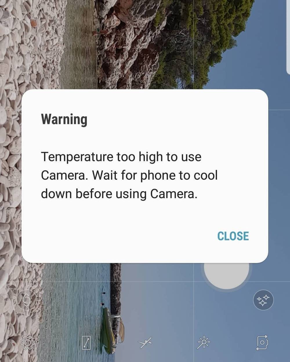 A phone camera warning: 'Temperature too high to use Camera. Wait for phone to cool down.'