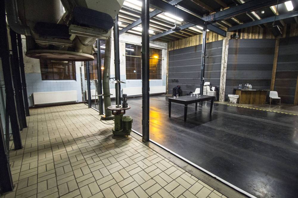 A similar view of the empty industrial hall set up with tables at De Fabrique.