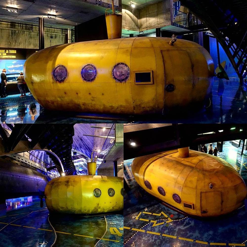 Small yellow submersible pods on display inside a museum exhibit.