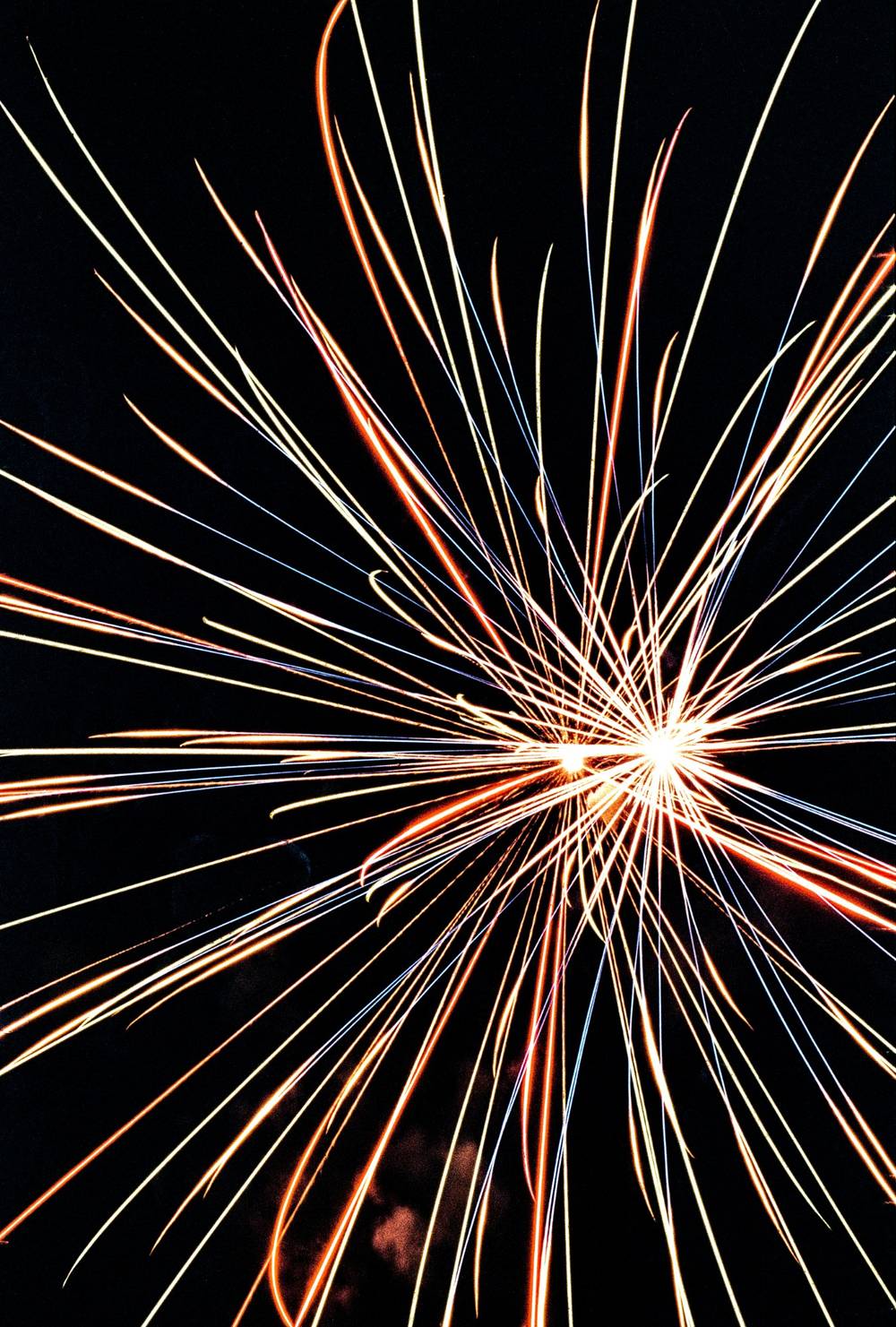 Long exposure shot of red, blue, and yellow fireworks.